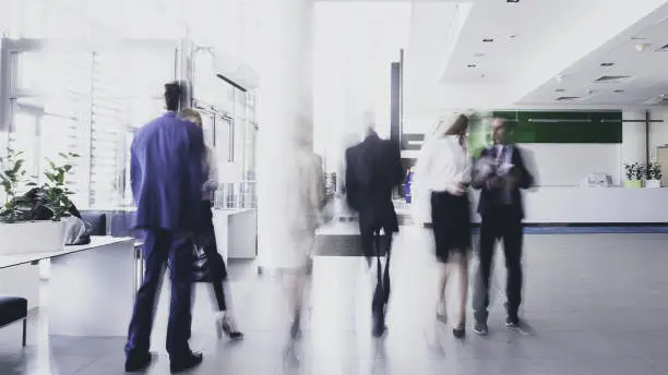 News Blog Image_Defocused Image People Walking in Office_iStockphoto-1153309639