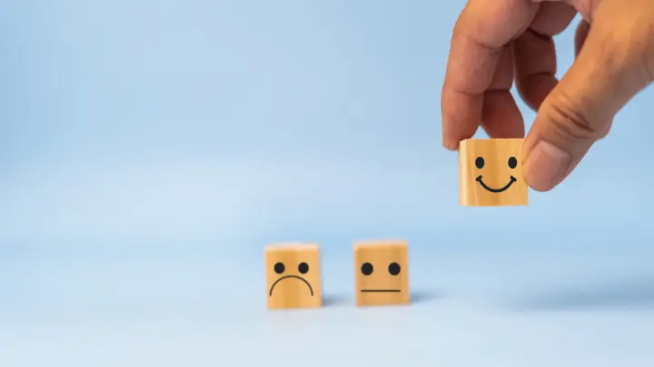 Three emoji blocks with a smiley block being picked up