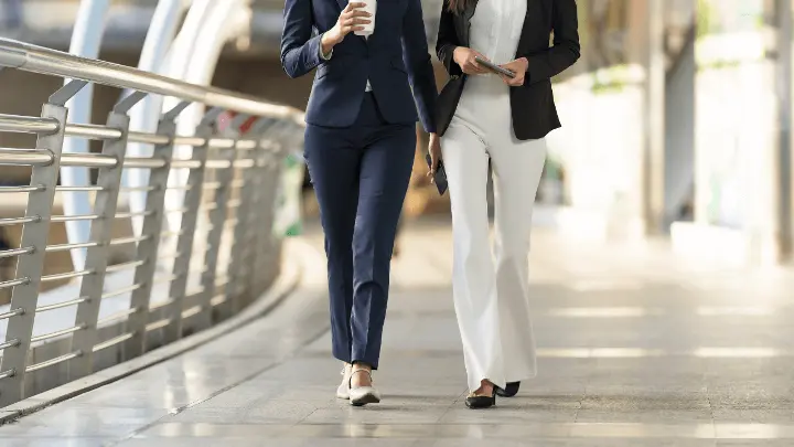 Two women walking down a hallway.