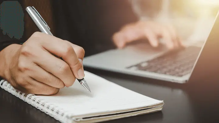 Person about to write in a blank notebook
